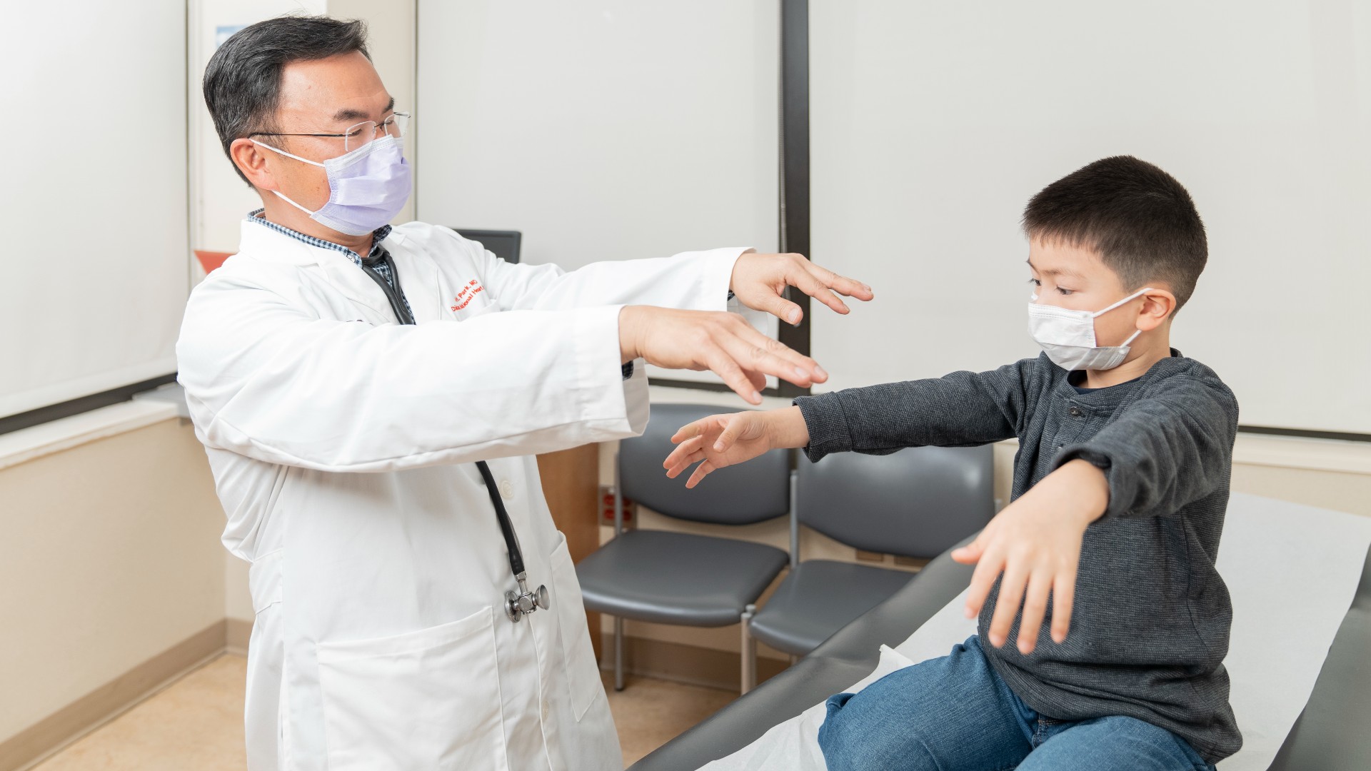 Young boy copying what provider is asking him to do for exam